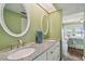 A double vanity with light countertops and decorative mirrors, near the bedroom entrance at 19925 Gulf Blvd # 105, Indian Shores, FL 33785