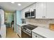 Kitchen featuring white cabinets, modern appliances, and a mosaic backsplash at 19925 Gulf Blvd # 105, Indian Shores, FL 33785