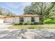 Close-up view of one-story home with a well-manicured lawn and a two-car garage at 2150 Shelly Dr # D, Palm Harbor, FL 34684