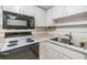 Close-up of the kitchen featuring white appliances, cabinets and tile backsplash at 2150 Shelly Dr # D, Palm Harbor, FL 34684