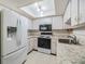 Bright kitchen showcasing white cabinets, appliances and countertops at 2150 Shelly Dr # D, Palm Harbor, FL 34684