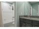 Bathroom boasts a shower-tub combo and a vanity with a granite countertop and a dark cabinet at 21874 Crest Meadow Dr, Land O Lakes, FL 34637