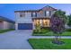Well-lit two-story home with manicured lawn and blue shutters at 21874 Crest Meadow Dr, Land O Lakes, FL 34637