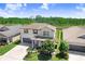 Two-story home with manicured lawn, gray siding, dark shutters, and a two-car garage, located beside a lake at 21874 Crest Meadow Dr, Land O Lakes, FL 34637