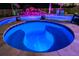 Inviting hot tub with custom tile surround and view of the pool and rock waterfall feature at 21874 Crest Meadow Dr, Land O Lakes, FL 34637