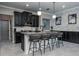 Gourmet kitchen showcasing an island, elegant pendant lights, black cabinets, and marble backsplash at 21874 Crest Meadow Dr, Land O Lakes, FL 34637