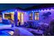Back patio with outdoor kitchen, colorful lighting, and well-manicured garden areas at 21874 Crest Meadow Dr, Land O Lakes, FL 34637