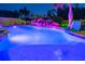 Resort-style swimming pool with cascading rock features and in-pool seating, lit for nighttime use at 21874 Crest Meadow Dr, Land O Lakes, FL 34637