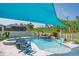 Beautiful kidney-shaped pool and spa area with rock waterfall feature and blue shade covering at 21874 Crest Meadow Dr, Land O Lakes, FL 34637