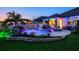 Stunning backyard pool and spa with rock waterfall, palm trees, and colorful landscaping at 21874 Crest Meadow Dr, Land O Lakes, FL 34637