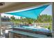 Outdoor kitchen and bar top overlooking beautiful pool with rock waterfall feature and blue shade covering at 21874 Crest Meadow Dr, Land O Lakes, FL 34637