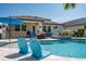 Backyard pool featuring in-pool seating, with an outdoor kitchen and comfortable seating on the patio at 21874 Crest Meadow Dr, Land O Lakes, FL 34637