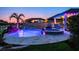Gorgeous backyard pool and jacuzzi with waterfall feature, palm trees, and patio furniture at 21874 Crest Meadow Dr, Land O Lakes, FL 34637
