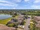 Aerial shot of a property with a serene lake view and palm trees at 2407 Kensington Greens Dr, Sun City Center, FL 33573