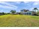 Expansive backyard view showing the home's sunroom, lawn, and lush landscaping at 2407 Kensington Greens Dr, Sun City Center, FL 33573