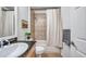 This bathroom showcases a granite vanity and a bathtub with tiled walls and a shower curtain at 2407 Kensington Greens Dr, Sun City Center, FL 33573