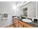 Bright bathroom featuring a double vanity with granite countertops and ample lighting at 2407 Kensington Greens Dr, Sun City Center, FL 33573