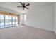 Large bedroom with ceiling fan, carpet flooring and a sliding glass door to the lanai at 2407 Kensington Greens Dr, Sun City Center, FL 33573