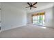 Spacious carpeted bedroom with a ceiling fan and sliding glass doors to a screened in patio at 2407 Kensington Greens Dr, Sun City Center, FL 33573
