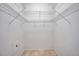 Empty walk-in closet with basic shelving and tile flooring, ready for organization at 2407 Kensington Greens Dr, Sun City Center, FL 33573