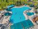 Large community pool with ample seating and umbrellas surrounded by palm trees and lounge chairs at 2407 Kensington Greens Dr, Sun City Center, FL 33573