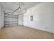 Spacious garage with neutral walls, a garage door, and a doorway to provide easy access at 2407 Kensington Greens Dr, Sun City Center, FL 33573