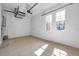 The spacious garage has neutral walls, windows, and a doorway to provide easy access at 2407 Kensington Greens Dr, Sun City Center, FL 33573