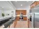 Modern kitchen featuring stainless steel appliances, wooden cabinets, and granite countertops at 2407 Kensington Greens Dr, Sun City Center, FL 33573
