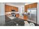 Well-lit kitchen with stainless steel appliances, wood cabinetry, and granite countertops at 2407 Kensington Greens Dr, Sun City Center, FL 33573