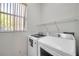 Well-lit laundry room featuring a side-by-side washer and dryer at 2407 Kensington Greens Dr, Sun City Center, FL 33573