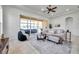 Spacious living room featuring tile floors, a ceiling fan, and sliding glass doors to the sunroom at 2407 Kensington Greens Dr, Sun City Center, FL 33573