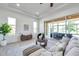 Bright living room with a ceiling fan and large windows offering a view of the outdoors at 2407 Kensington Greens Dr, Sun City Center, FL 33573