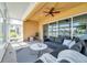 Well-lit sunroom with stylish gray couches, textured floors, and lake views at 2407 Kensington Greens Dr, Sun City Center, FL 33573