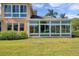 Exterior shot featuring a sunroom with multiple windows offering beautiful views of the yard at 2407 Kensington Greens Dr, Sun City Center, FL 33573