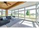 Bright sunroom filled with windows offering panoramic views of the landscape and a comfortable seating area at 2407 Kensington Greens Dr, Sun City Center, FL 33573