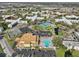 Aerial view shows a tennis court, pool, and clubhouse surrounded by lush landscaping at 2416 World Parkway Blvd # 26, Clearwater, FL 33763