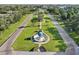 Aerial view of a tree-lined street with manicured medians and a central globe fountain at 2416 World Parkway Blvd # 26, Clearwater, FL 33763