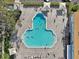 An aerial view shows a unique pool shape with lounge seating and a well landscaped area at 2416 World Parkway Blvd # 26, Clearwater, FL 33763