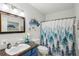 Full bathroom with forest-themed shower curtain and bright vanity area at 2416 World Parkway Blvd # 26, Clearwater, FL 33763