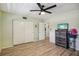 Bright bedroom features wood-look floors, ceiling fan, and a closet with white sliding doors at 2416 World Parkway Blvd # 26, Clearwater, FL 33763
