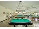 Large billiards room showcasing multiple pool tables with overhead lighting, providing an engaging community space at 2416 World Parkway Blvd # 26, Clearwater, FL 33763