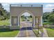 View of a monumental entry gate with a landscaped median and globe fountain at 2416 World Parkway Blvd # 26, Clearwater, FL 33763