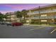 Inviting condo building with manicured landscaping, ample parking, and vibrant palm trees at 2416 World Parkway Blvd # 26, Clearwater, FL 33763