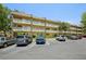 Condo exterior featuring balconies, ample parking, and nicely manicured landscaping with palm trees at 2416 World Parkway Blvd # 26, Clearwater, FL 33763