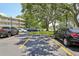 View of the condo parking lot with ample parking and mature trees providing shade at 2416 World Parkway Blvd # 26, Clearwater, FL 33763