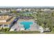 Aerial view of a clover shaped outdoor pool and deck area with lounge chairs, tennis court, and parking at 2416 World Parkway Blvd # 26, Clearwater, FL 33763