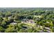 Wide aerial shot of the property displaying lush tree coverage, home, long drive and neighborhood setting with beautiful greenery at 26438 Glenwood Dr, Wesley Chapel, FL 33544