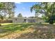 Expansive backyard featuring a well-maintained lawn and a home exterior with sliding glass doors and access to a verdant outdoor space at 26438 Glenwood Dr, Wesley Chapel, FL 33544