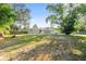 Expansive backyard featuring a well-maintained lawn and a home exterior with sliding glass doors and access to a verdant outdoor space at 26438 Glenwood Dr, Wesley Chapel, FL 33544