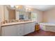 Bathroom featuring a soaking tub, shower, and large vanity with ample counter space at 26438 Glenwood Dr, Wesley Chapel, FL 33544
